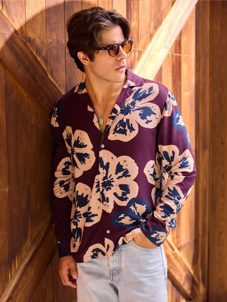 A man in sunglasses wears a floral long sleeve shirt